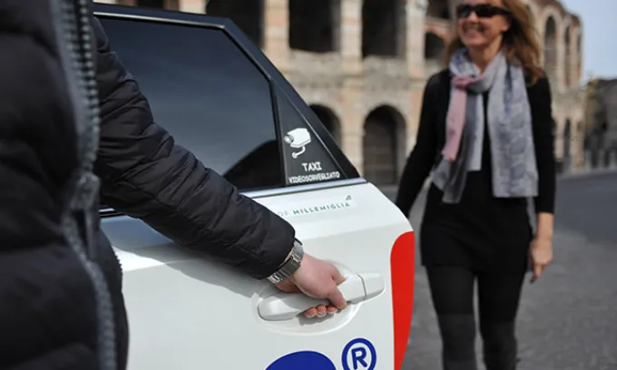 a woman enters a taxi in Verona