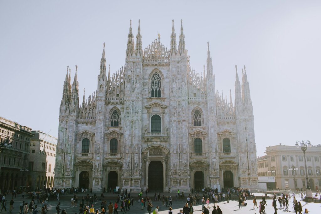 the Duomo in central Milan with tourists walking by in the daytime