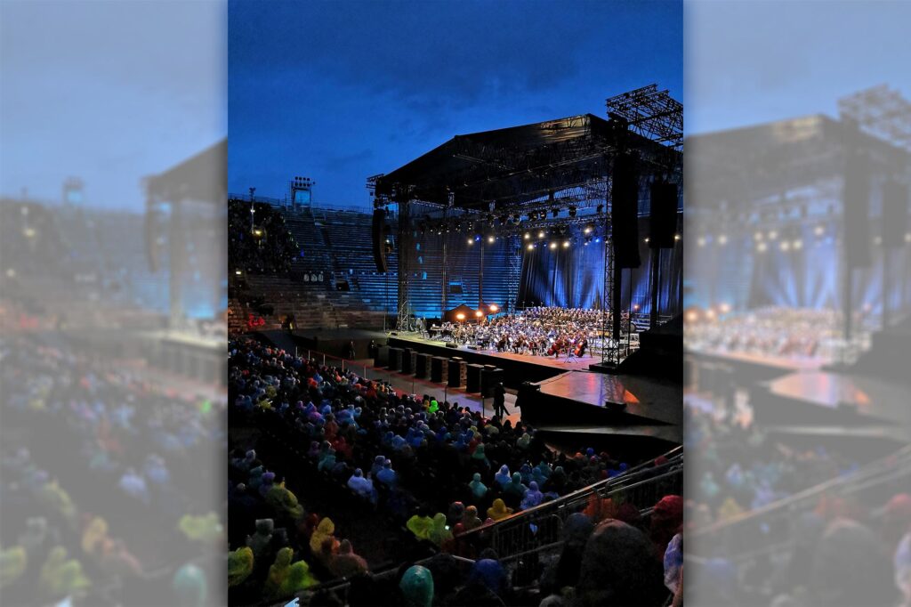 a crowd watches a concert at night at the Verona Arena