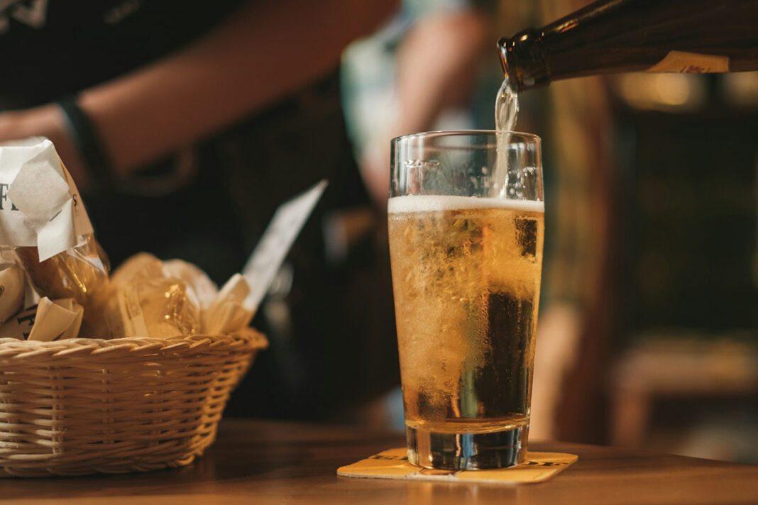 Beer being poured into a glass in a brewery