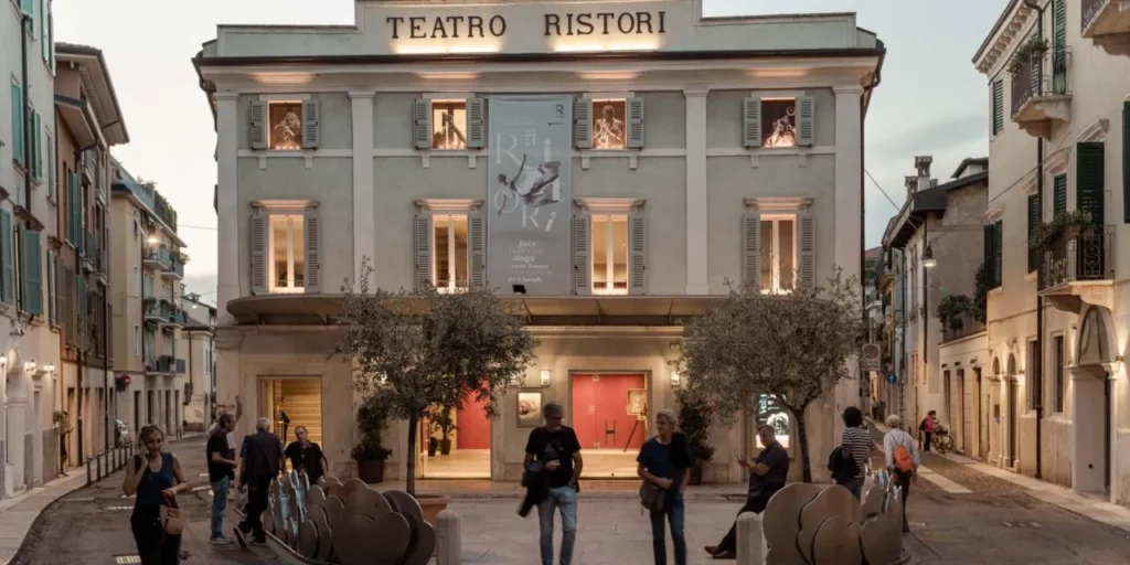 the outside of the Teatro Ristori with tourists walking by